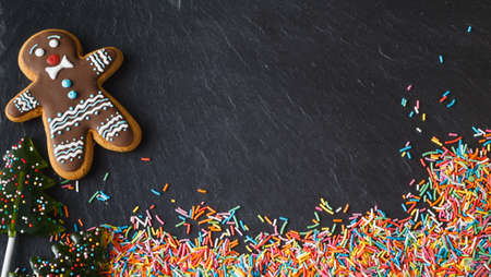 Christmas Day invitation card with sweets on black slateの写真素材