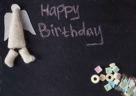 Kid birthday invitation card. Angel and sweets on slate backgroundの写真素材
