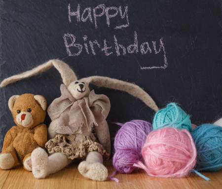 happy birthday banner. Handwriting message on chalk board with felt dollの写真素材
