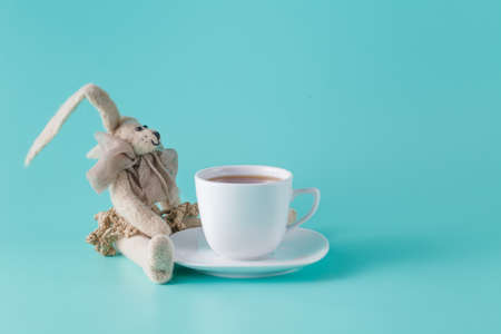 Nostalgic breakfast concept. Rabbit doll with cup of coffeeの写真素材