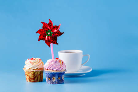 Two cupcakes on blue background with whirligigの写真素材