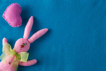 Kid toy play concept. Frame with soft felt and handmade funny pink rabbitの写真素材