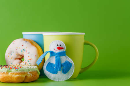 Donuts breakfas with christmas decoration on green backgroundの写真素材