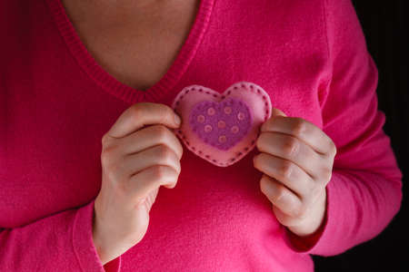 Romantic concept. Female in pink holding soft heart symbol