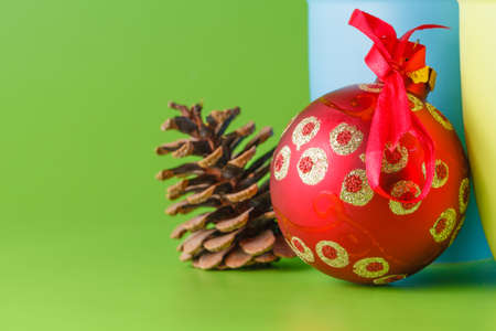 Christmas hot drink with red ball and cone on green backgroundの写真素材