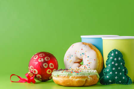 Donuts breakfas with christmas decoration on green backgroundの写真素材
