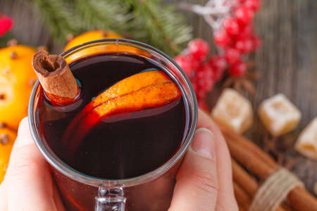 Heating winter drinks. Female hold glass of hot mulled wineの写真素材