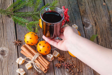 Heating winter drinks. Female hold glass of hot mulled wineの写真素材