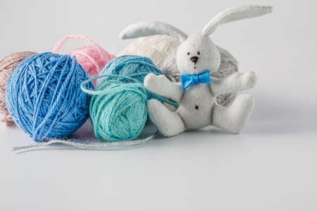Hobby needlework concept. Handmade felt toy bunny with colored wool clewの写真素材
