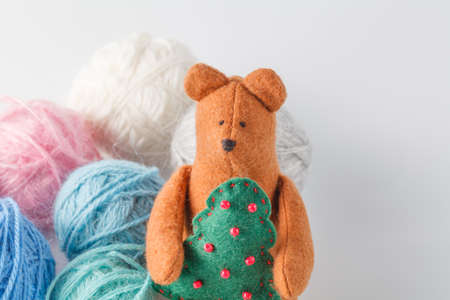 Hobby needlework concept. Handmade felt toy bear with colored wool clewの写真素材