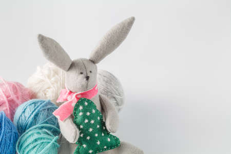 Hobby needlework concept. Handmade felt toy bunny with colored wool clewの写真素材