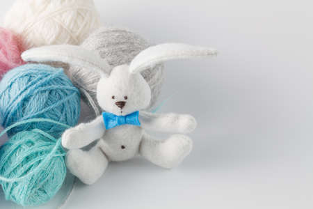 Hobby needlework concept. Handmade felt toy bunny with colored wool clewの写真素材