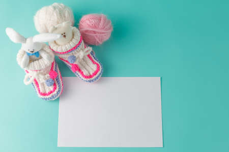 Newborn announcement concept. Knitted booties on aquamarine backgroundの写真素材