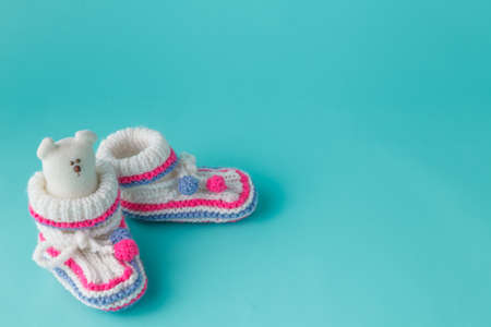 Newborn announcement concept. Knitted booties on aquamarine backgroundの写真素材