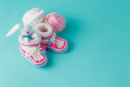 Newborn announcement concept. Knitted booties on aquamarine backgroundの写真素材