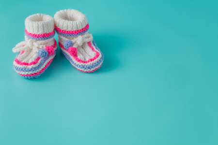 Newborn announcement concept. Knitted booties on aquamarine backgroundの写真素材