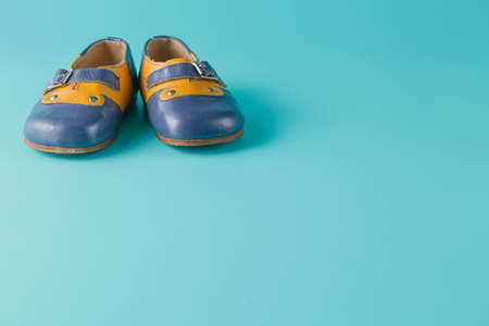 Baby birthday announcement. Retro leather booties on aquamarine backgroundの写真素材