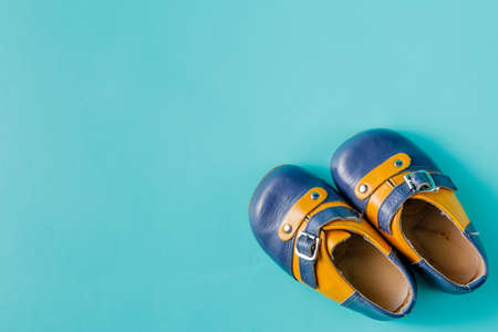 Baby birthday announcement. Retro leather booties on aquamarine backgroundの写真素材