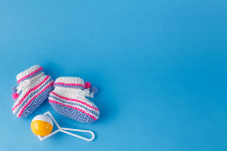 Newborn announcement template. Handmade knitted booties  on plain backgroundの写真素材