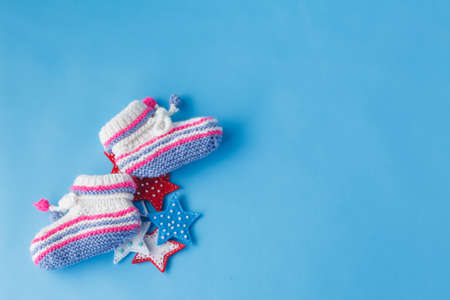 First year birthday invitation template. Handmade knitted tiny booties with copyspaceの写真素材