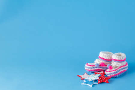 First year birthday invitation template. Handmade knitted tiny booties with copyspaceの写真素材