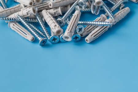 Group of screws on plain blue background with copyspace