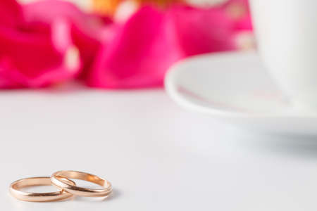 Wedding banner concept. Golden wedding rings with rose petals.の写真素材