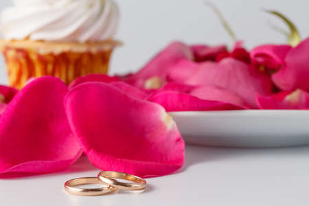 Wedding day breakfast decoration details. Rose petals and wedding ringsの写真素材