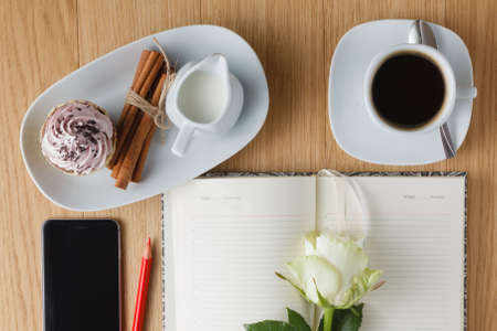 Cup of coffee with notebook and mobile phone