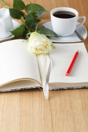 rose and empty notebook page on wood backgroundの写真素材