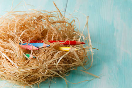 Two pink paper hearts in a small nest on wooden background.の写真素材