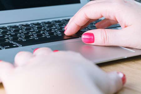 Closeup of woman hand typing on laptop keyboard