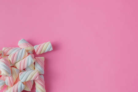 Colored tweested marshmallow on pink background