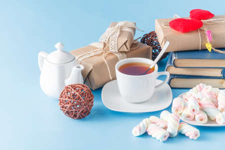 Cup of black tea, marshmallow  and old books on the blue tableの写真素材