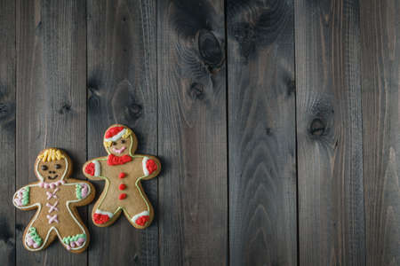 Two cookies gingerbread man on aged wooden table