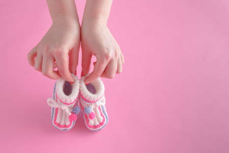Motherhood concept. Female hold tiny newborn booties