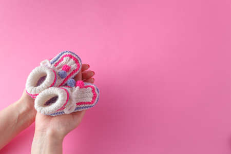 Motherhood concept. Female hold tiny newborn booties