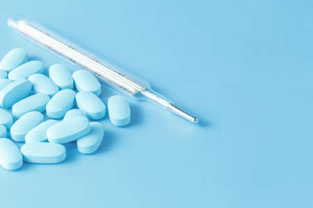 Drugs on blue background. Concept treatment fever