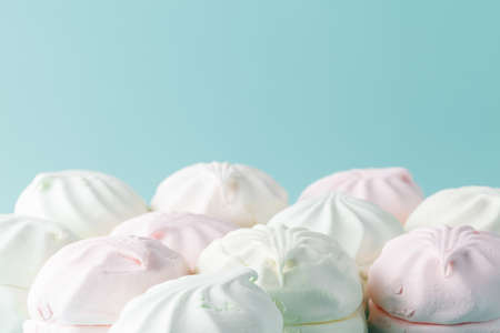 Pastel colored marshmallow  on aquamarine vibrant backgroundの写真素材