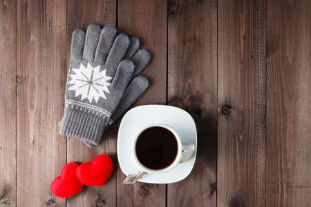 Top view of Cup of black coffee with  gloves on wooden backgroundの写真素材
