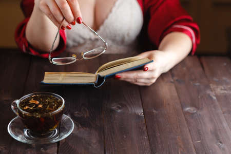 Woman sitting reading book and drink teaの写真素材