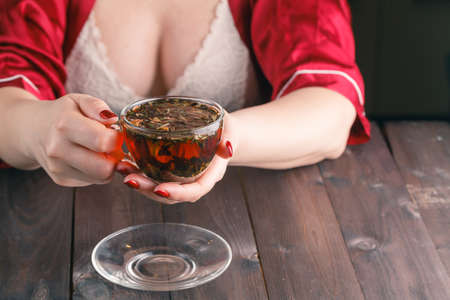 woman working on computer at home at night with tea cupの写真素材