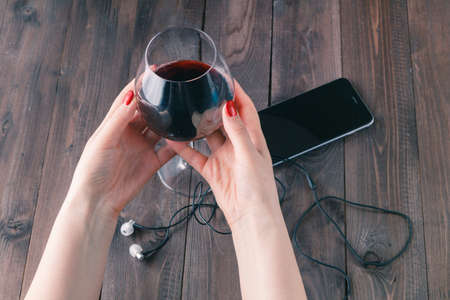 Women drinking wine. Top view of beautiful woman holding wineの写真素材