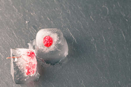 Ice cubes with red currant, on wooden backgroundの写真素材