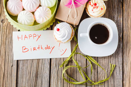 Delicate meringues and marshmallows with coffee and message happy birthdayの写真素材
