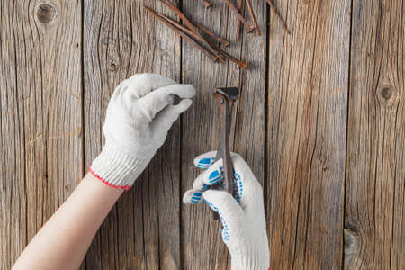 pliers and few rust nails on wood background