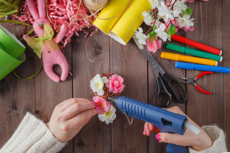 Woman glue handmade flowers with melt gun. Top viewの写真素材