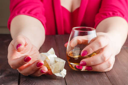 woman crush paper note and drink alcoholの写真素材