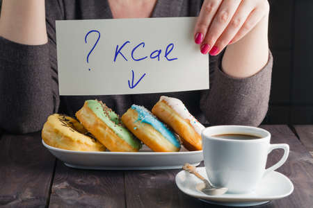 How much calories in sweet donuts, woman hold note with questionの写真素材