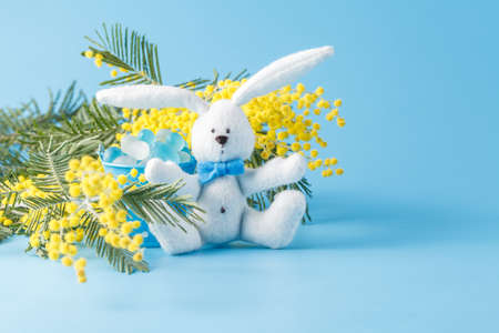 White toy rabbit and yellow mimosa. Spring decorationの写真素材